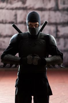 a man in a ninja suit holding two swords