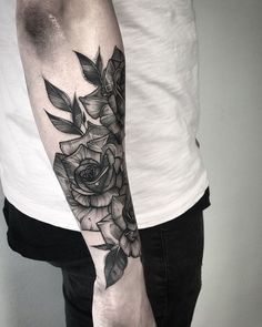 a black and white rose tattoo on the arm