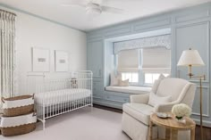 a baby's room with a crib, chair and window