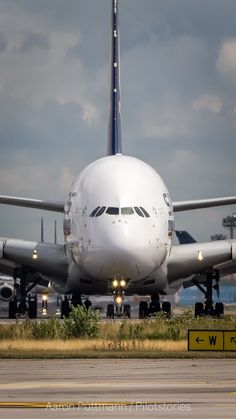 an airplane is sitting on the tarmac with other planes in the distance behind it