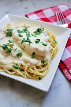 a white plate topped with pasta covered in gravy