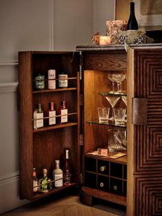 an open cabinet filled with liquor bottles and glasses