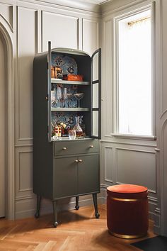 an old fashioned cabinet is in the corner of a room with hardwood floors and walls