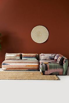 a living room with a couch and rugs in front of a wall painted red