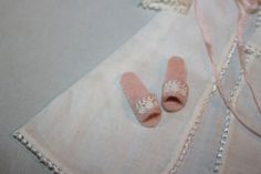 a pair of pink slippers sitting on top of a white cloth