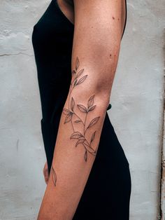 a woman's arm with a flower tattoo on the left side of her arm