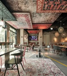 a restaurant with tables, chairs and rugs on the floor