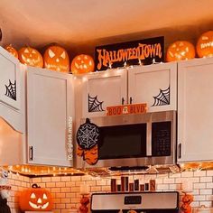 a kitchen decorated for halloween with pumpkins and lights