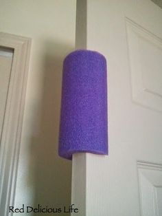 a purple lamp hanging from the side of a white wall next to a door with an instagram button on it