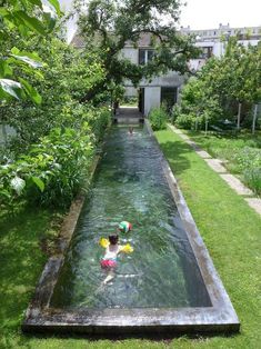 a young child playing in the water near a pool