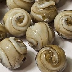 there are many different types of beads on the table, one is white and has brown swirls