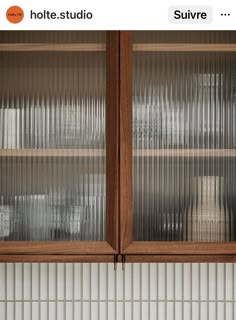 two wooden cabinets with glass doors in a kitchen