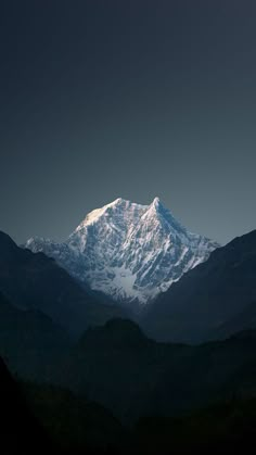 a snow covered mountain in the distance under a dark sky with no clouds on it