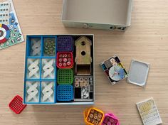 an open box filled with lots of different types of magnets on top of a wooden table