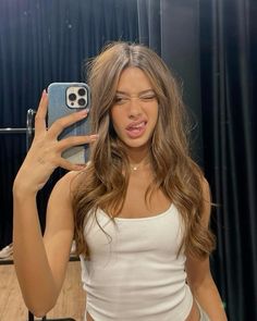 a woman taking a selfie in front of a mirror