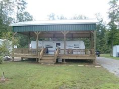 a mobile home sits in the middle of a grassy area with stairs leading up to it