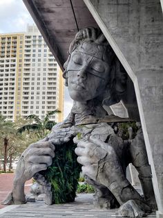 there is a statue that looks like a woman holding a plant