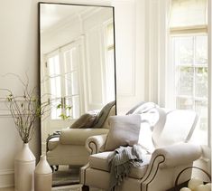 a living room filled with furniture and a large mirror