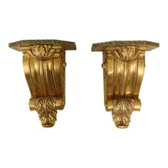 a pair of gold colored wall sconces with green marbles on each side