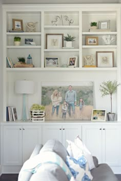 a white bookcase filled with books and pictures