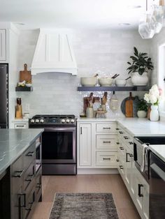 a kitchen with white cabinets and stainless steel appliances, including an area rug in the middle