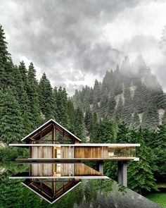 a house in the middle of a lake surrounded by trees and mountains is reflected in the water