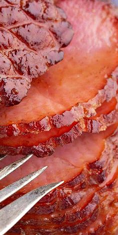 the bacon is being cut into pieces with tongs