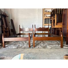 two wooden beds sitting next to each other on top of a carpeted floor in a room