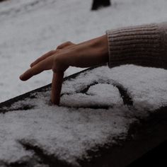 a person's hand reaching for something in the snow