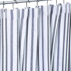 a shower curtain with black and white striped fabric hanging from it's metal rod