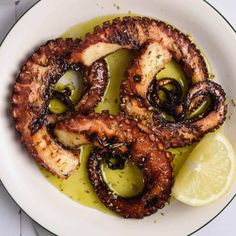 octopus rings with olives and lemon on a white plate, ready to be eaten