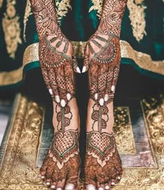 the feet and hands of a woman with henna tattoos