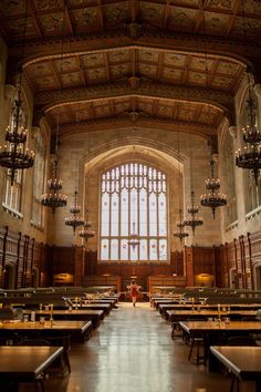 the inside of a large building with tables and chandeliers hanging from the ceiling