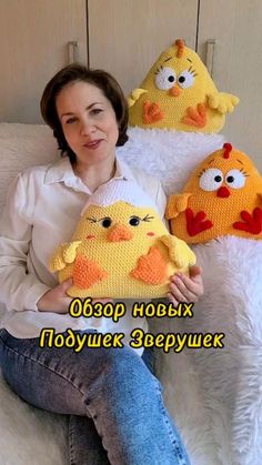 a woman sitting on a white couch holding three stuffed animals in different colors and sizes