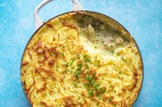 a casserole dish with meat and vegetables in it on a blue tablecloth