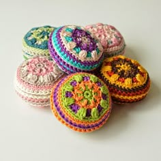 four crocheted round coasters sitting next to each other on a white surface