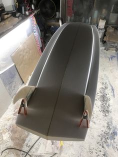 a surfboard sitting on top of a table in a room filled with other items