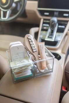 the interior of a car with various items in its holder and steering wheel behind it