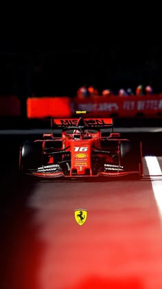 a red race car driving on a track at night