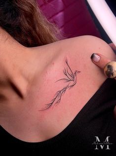 a woman with a bird tattoo on her shoulder