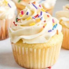 several cupcakes with white frosting and sprinkles