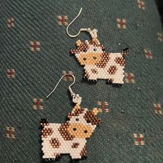 the earrings are made out of bead and have a cow design on each earring