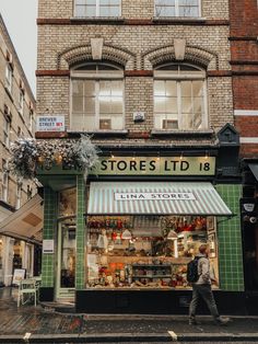 a man walking past a store front on a city street