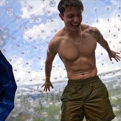 a shirtless man standing in front of a large bubble