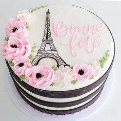 a cake decorated with pink flowers and the eiffel tower in paris, france