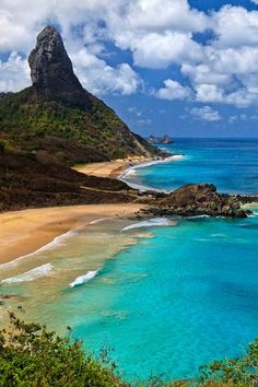 the beach is surrounded by blue water and mountains