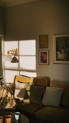 the sun shines through the window onto a couch and coffee table in this living room