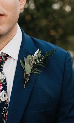 a man wearing a blue suit and flower boutonniere