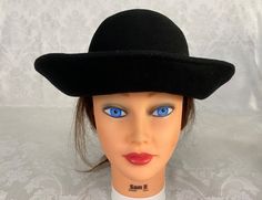 "Here we have a vintage mid-century Woman's black Bucket Hat. This has a wide rolled brim that measures 3\" and a pretty velvet bow on the back. The circumference is 21\". This could use a good brushing. I try my best to give accurate descriptions, although I am no expert, plus I'm human and sometimes I might miss a flaw. I always provide high resolution photos and consider them to be part of the description. I encourage you to zoom in and examine them closely as they show exactly what you will Vintage Black Cloche Hat, Black Vintage Cloche Hat, Vintage Black Brimmed Hat, Vintage Black Hat For Church, Vintage Black Wide Brim Hat, Black Wide Brim Vintage Hat, Black Brimmed Retro Hat, Vintage Black Adjustable Hat, Black Retro Brimmed Hat