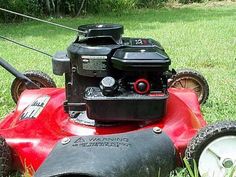 a red lawn mower sitting in the grass